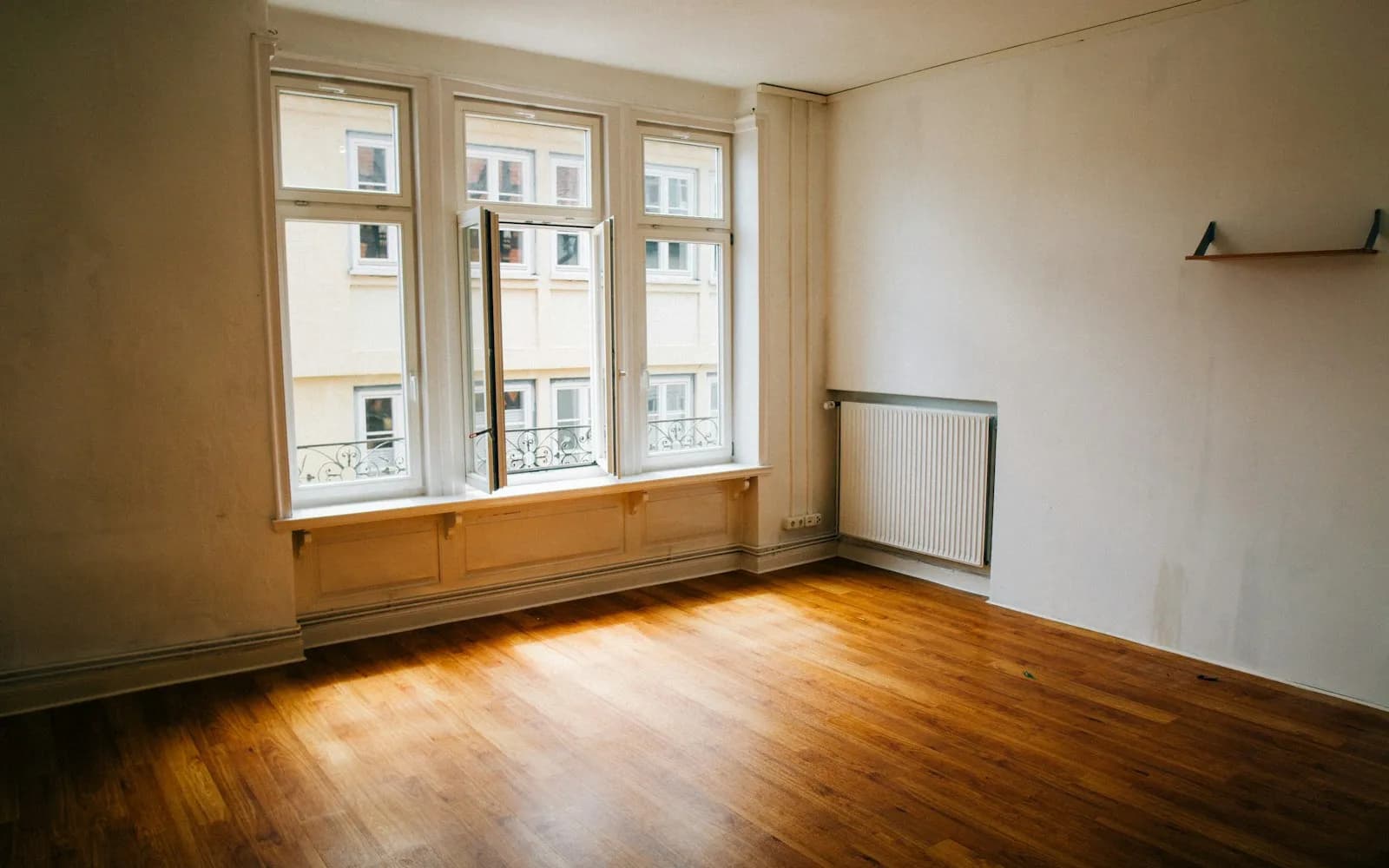 Pièce vide et sobre, parquet et lumière douce — nettoyage après décès